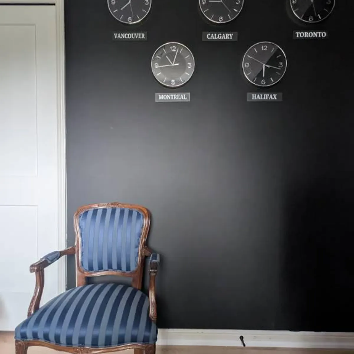 Canadian city clocks mounted on a black feature wall